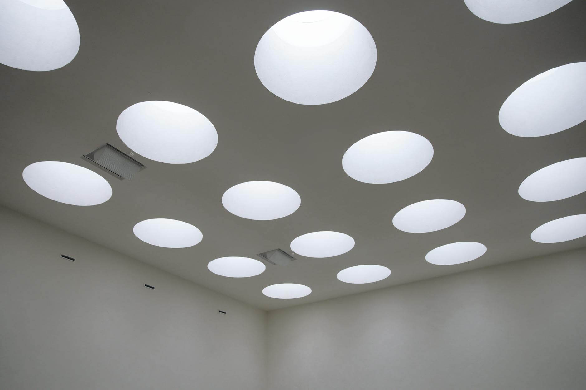 A modern room featuring circular ceiling lights creating a unique geometric pattern.